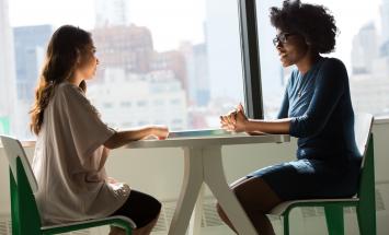 Two people chatting at a table