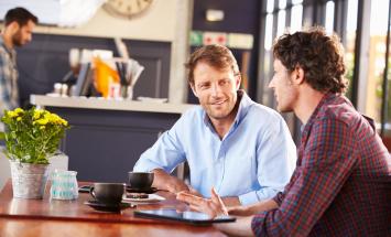 Two people chatting at a table