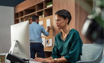 Person in a green shirt working at the computer 