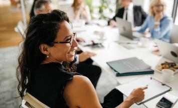 Woman sitting at table with clipboard