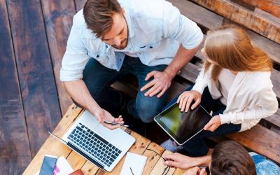 people around a table with laptops and tablets